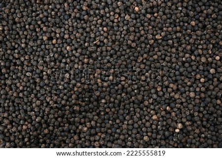 Black pepper background. black peppercorns spices. herb. bed covered in full screen. Dry black pepper seeds. Top view. Flat design. Macro spice background Royalty-Free Stock Photo #2225555819