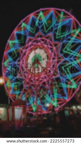 defocused abstract background of ferris wheel and colorful lights at night