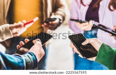 Closeup of people hands using data on mobile smart phones - Detail of web users sharing images on social media with smartphones - Tech and cellphone culture concept with selective focus on right thumb