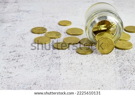 Close up, euros, coins in a jar on a table and scattered. Economic concept and copy space.