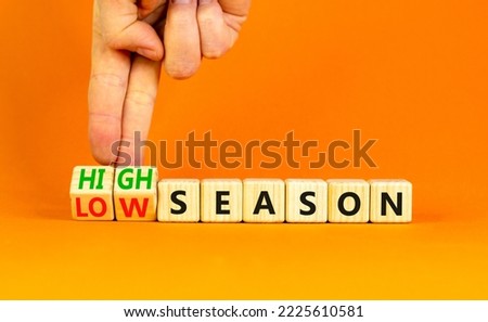 High or low season symbol. Concept words High season and Low season on wooden cubes. Businessman hand. Beautiful orange table orange background. Business high or low season concept. Copy space.