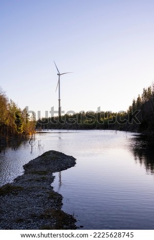Wind generator on background on a small riverbank