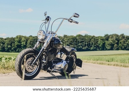 black motorcycle without a driver stands on a dirt road, sideview Royalty-Free Stock Photo #2225635687