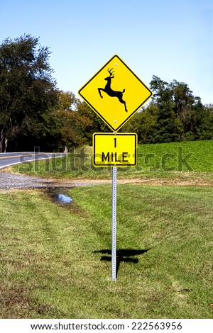 Deer crossing sign on country road warning travelers of deers passing through