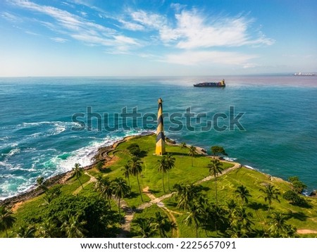 Aerial view of lighthouse Faro San Souci and cargo container ship on the horizon. Entrance to the port of Santo Domingo at Ozama river. Dominican Republic Royalty-Free Stock Photo #2225657091