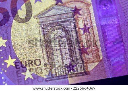 Euro currency in UV light protection. Euro in UV light to check the authenticity of the money.