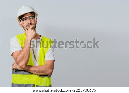 Pensive builder man with hand on chin, Portrait of young builder thinking with hand on chin isolated, A pensive engineer on white background. Concept of a meditative engineer solated Royalty-Free Stock Photo #2225708695