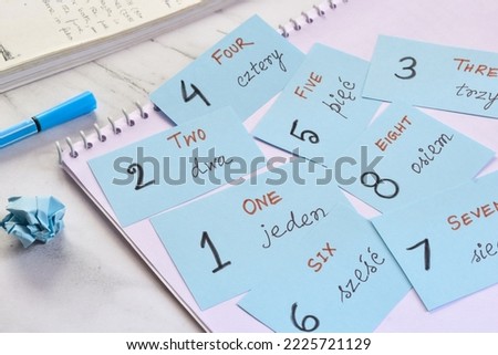 Learning Polish language with numbers concept. Flash cards with the numbers written in both English and Polish on study desk. Selective focus. Royalty-Free Stock Photo #2225721129