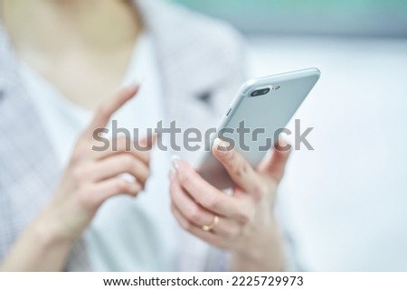Hands of a woman who operates a smartphone