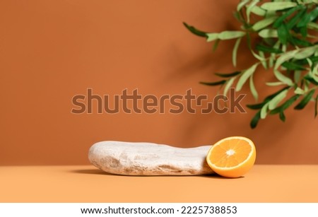 Beautiful template composition of empty mockup stage for product presentation made with stone, orange fruit and olive tree leaves. Royalty-Free Stock Photo #2225738853