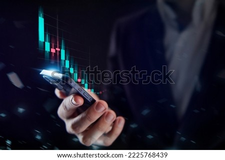 Business, finance and investment, forex trading, currency exchange, economic growth, stock market analysis concept. Man using mobile phone checking stock market graph report via mobile apps Royalty-Free Stock Photo #2225768439