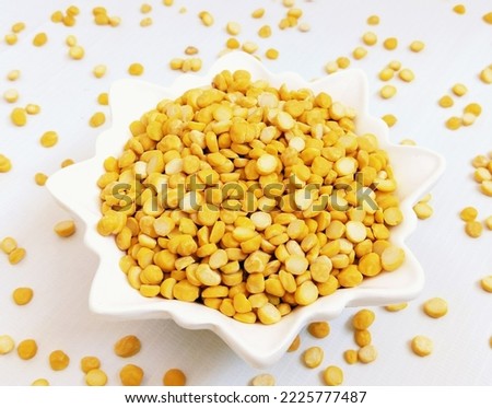 Split chickpeas legume dal chana Bengal gram lentils pulse yellow organic food full with protein harbara channa daal uncooked splitchickpea in a bowl closeup image picture stock photo focus on subject