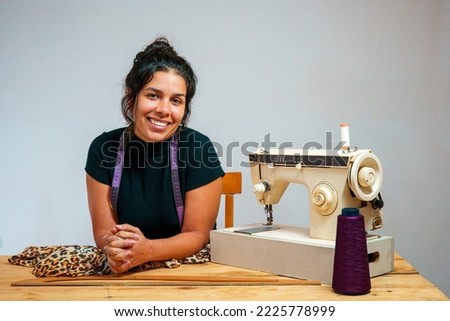 A dressmaker on a sewing machine. Jaguar pattern fabric. Royalty-Free Stock Photo #2225778999