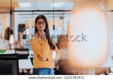 Female boss, manager executive posing in a modern startup office while being surrounded by her coworkers, team.