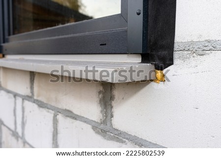 Warm installation of a three-layer window with a polystyrene window sill, view from the outside. Royalty-Free Stock Photo #2225802539
