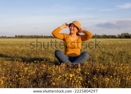 Beautiful model sitting in a spring meadow.