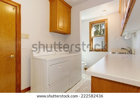 White laundry room with maple cabinets
