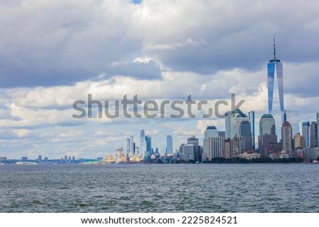 View of Manhattan skyscrapers on both sides of Hudson river under blue sky with white clouds. New York, USA.