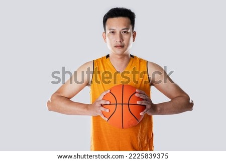 Male basketball player wearing sportswear holding basketball on white background with a determined face.
 Royalty-Free Stock Photo #2225839375