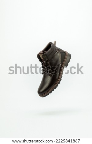 Flying men brown casual style boots over white background. Side view. Copy space for ad, design, text.