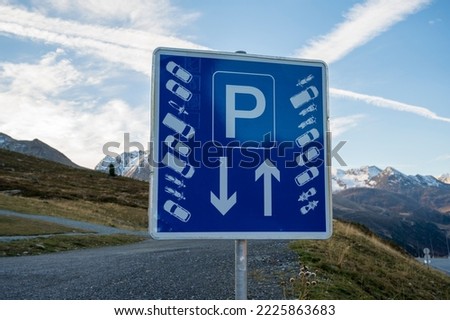 Blue road sign with marked parking high in the mountains.