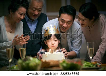 little asian girl blowing candles while three generation family celebrating her birthday at home Royalty-Free Stock Photo #2225868365