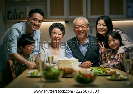 three generation asian family gathering at home celebrating senior couple's wedding anniversary Royalty-Free Stock Photo #2225870503