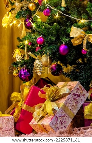 A beautiful Christmas tree card on the side with beautiful toys decorates an artificial Christmas tree for the New Year's holiday. Beautiful blurred background on the side