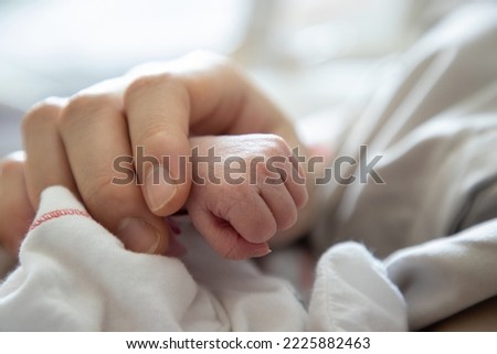 new born baby hand holded by  mum . concept : Premature or preterm baby in hospital. relationship between mother and baby. Royalty-Free Stock Photo #2225882463