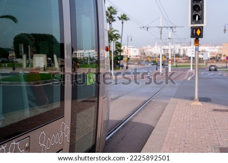 Modern tram passing by a traffic signal pole