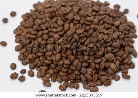 A pile of coffee beans on a white background, place for advertising, roasted coffee beans.