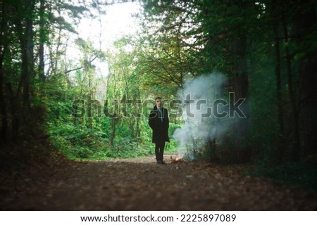 boy is standing by the fire with a lot of smoke,soft focus