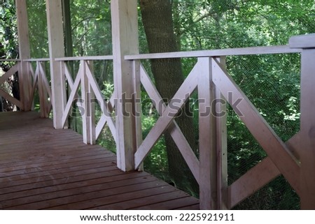 White wooden terrace. Railing. House in the green forest