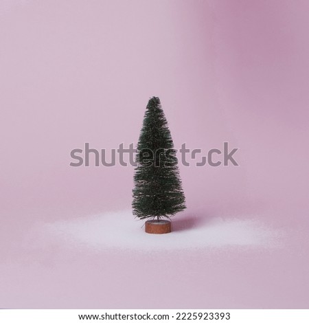 Isolated Christmas tree on pink background. Minimal concept with falling snow and copy space. Billbord, post card set design.1