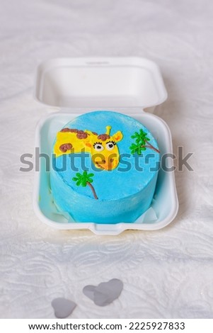 Bento cake for the holiday. A small cake with a picture or a congratulation for one person. A funny surprise dessert for a loved one. Cake with a giraffe