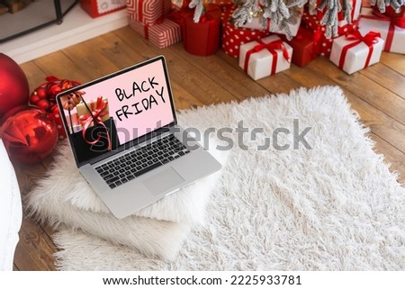 Black Friday shopping concept written in laptop's black screen against blurred christmas lights background