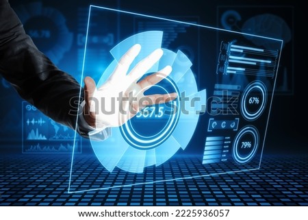 Close up of businessman hand using abstract glowing blue business charts and graphs hologram on dark background. Innovation, future and fintech concept