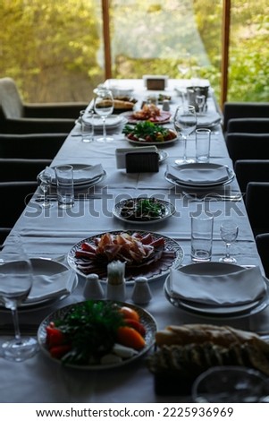 Set table, plates with food, glasses, glasses on a white tablecloth