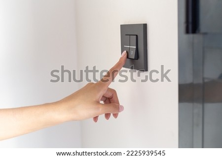 Close up of young woman's hand raising the blinds in her room with a button  Royalty-Free Stock Photo #2225939545