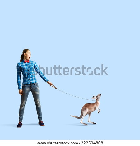 Young woman in casual holding kangaroo on lead