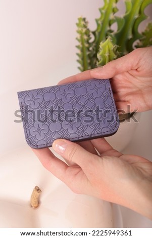 leather cardholder in human hands closeup photo on white wall background