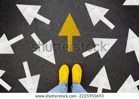 Different thinking and Business and technology disruption concept. Yellow big arrow opposite direction with white arrow on road asphalt. Standing out from the crowd