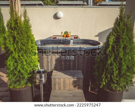 Close-up of modern bath tub with evergreen trees. Fresh fruits.