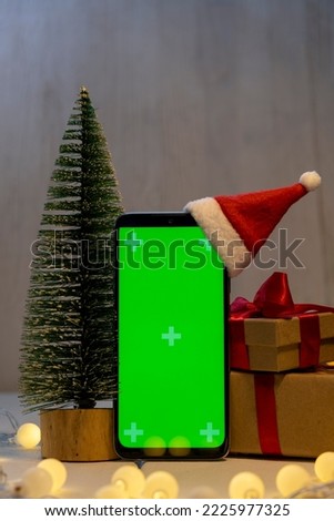 Smartphone with green screen on christmas decoration. Online shopping