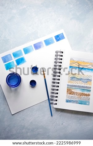 Top View of Blue Watercolors and a Watercolor Sampler in an Art Journal