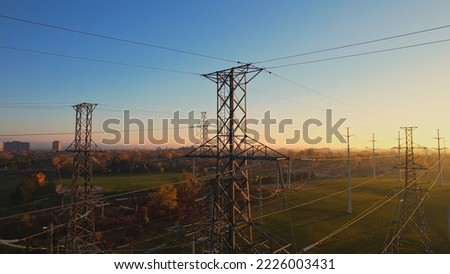 High voltage electricity pylon at golden hour background. International Earth Hour or power blackout concept. High electric hydro power demand due electric vehicle or EV use. 