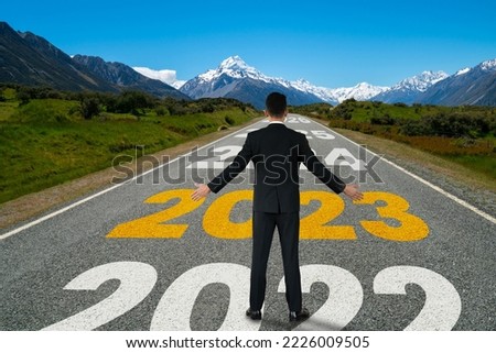 The 2023 New Year journey and future vision concept . Businessman traveling on highway road leading forward to happy new year celebration in beginning of 2021 for fresh and successful start . Royalty-Free Stock Photo #2226009505