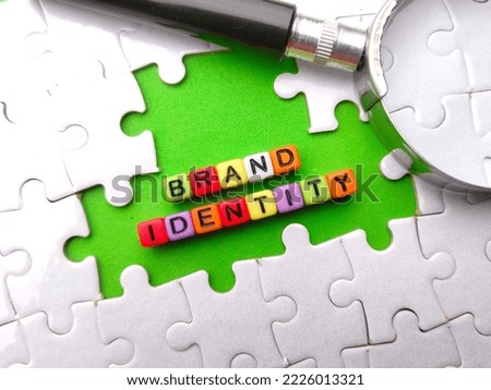 Selective focus.Colored dice and magnifying glass with the word BRAND IDENTITY. Business concept.