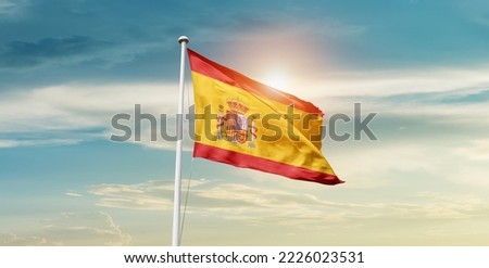 Spain national flag waving in beautiful clouds.