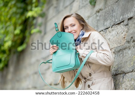 Young beautiful woman with handbag. Funny young woman in the street